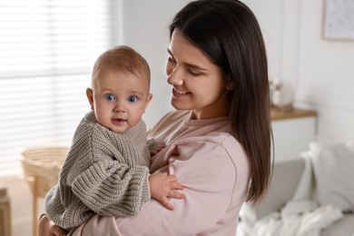 Photo of Happy young mother with her baby at home