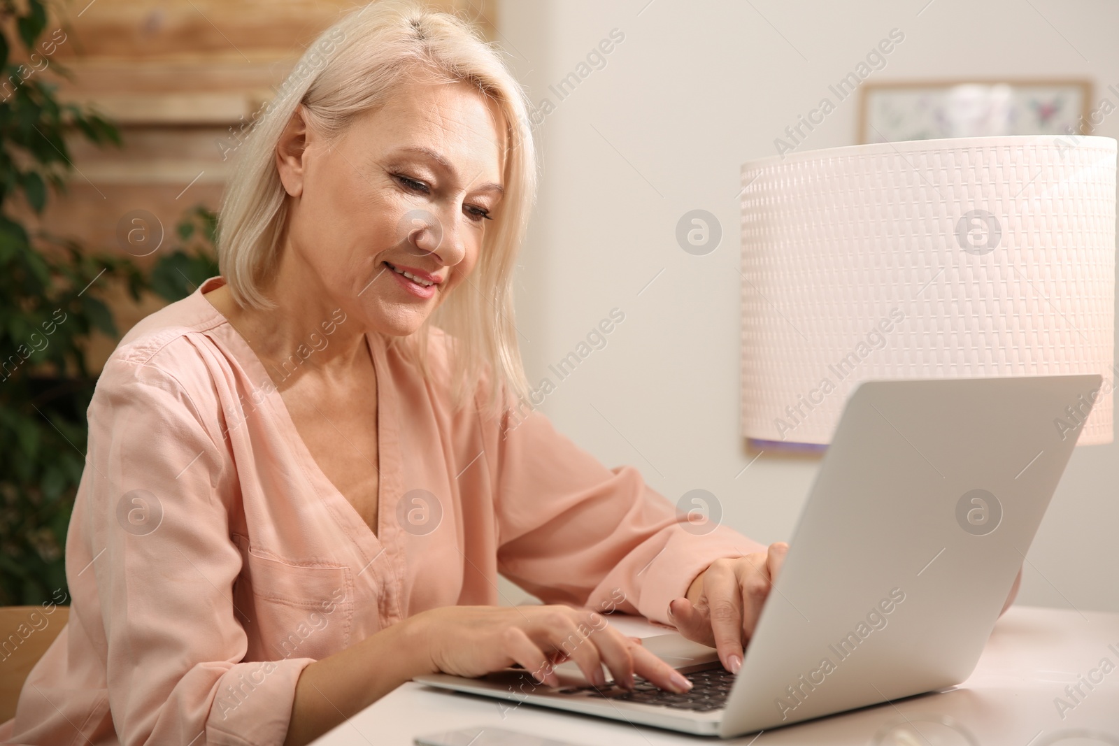 Photo of Beautiful mature woman working with laptop at home