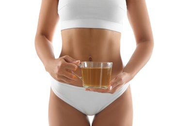 Photo of Young woman holding cup of diet tea on white background, closeup