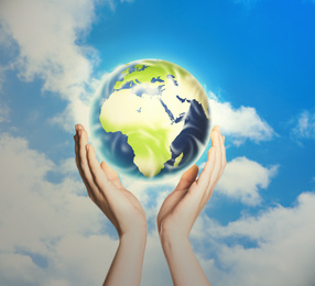 Image of Woman holding Earth against sky, closeup view