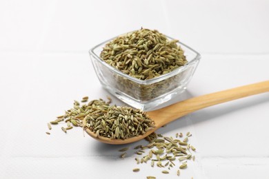 Bowl and spoon with fennel seeds on white table