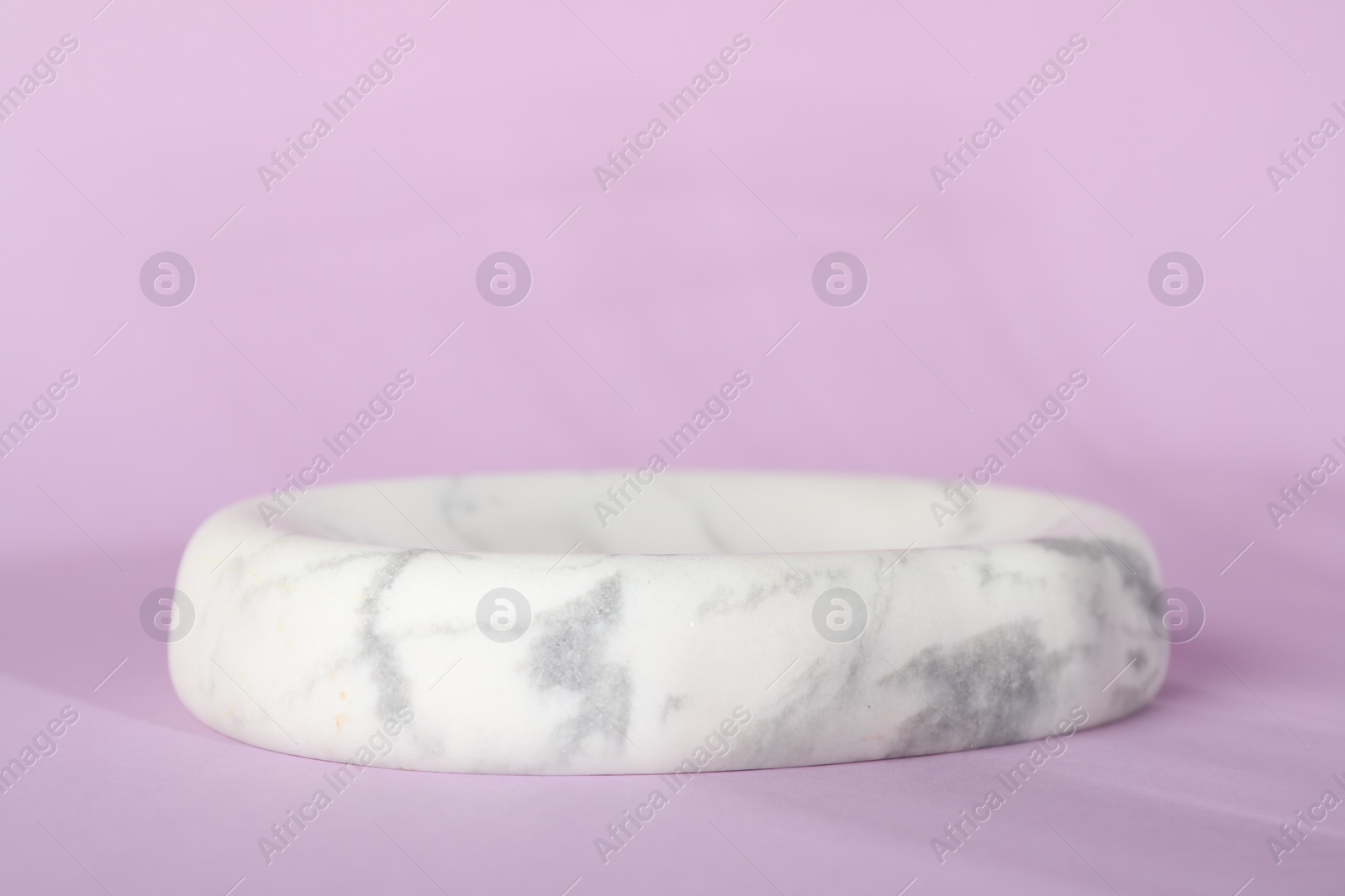 Photo of Presentation of product. White marble podium on violet background, space for text