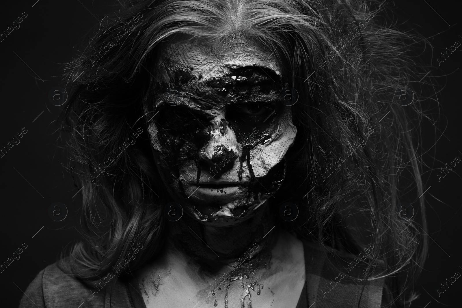 Photo of Scary zombie on dark background, black and white effect. Halloween monster