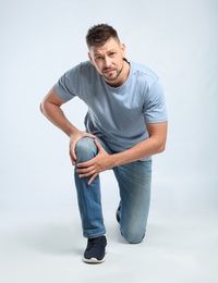 Photo of Full length portrait of man having knee problems on grey background
