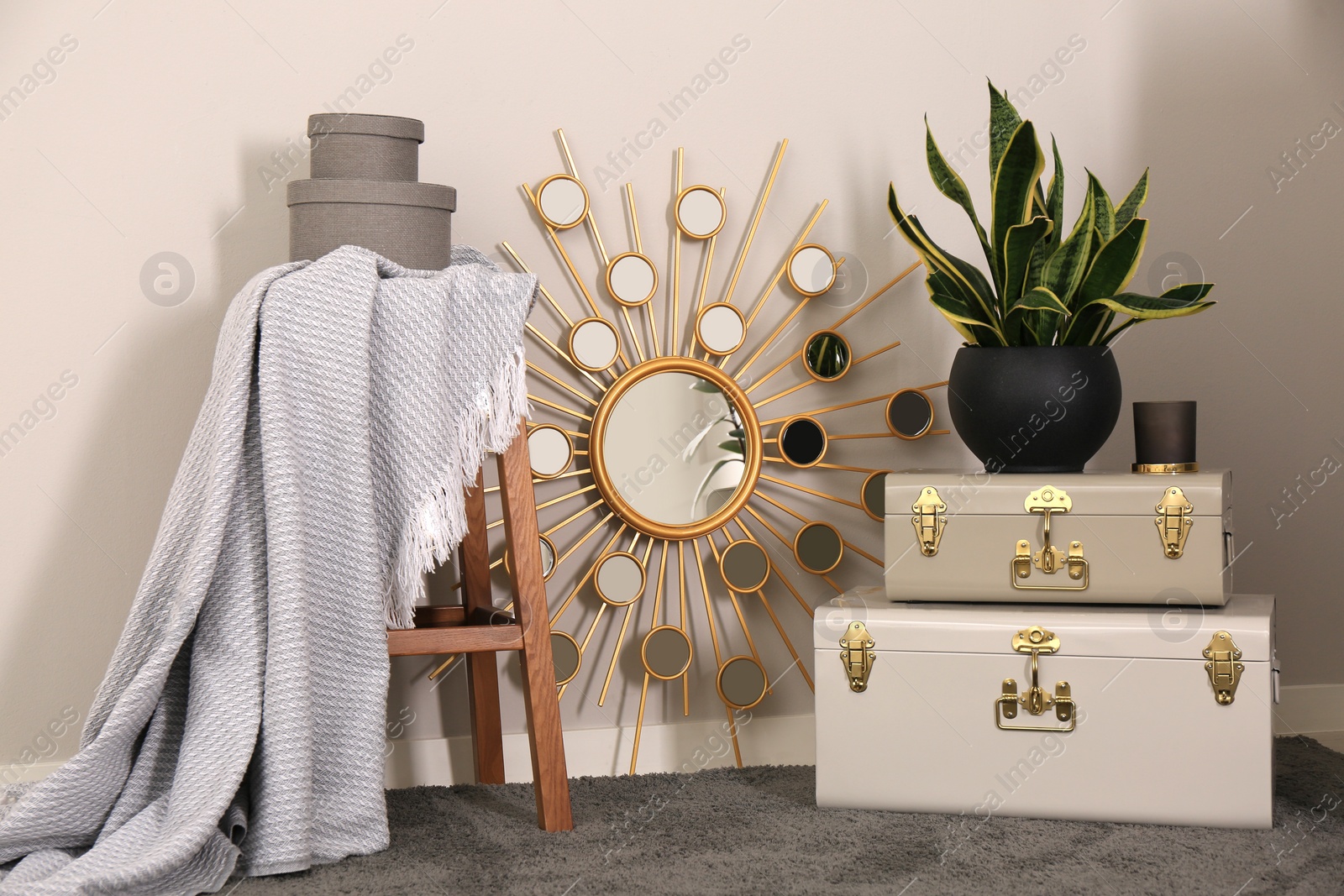 Photo of Stylish room interior with storage trunks, wooden stool and mirror