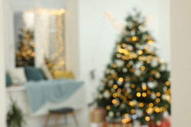 Photo of Blurred view of decorated Christmas tree in room. Interior design