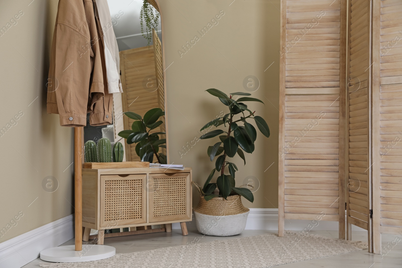 Photo of Stylish hallway room interior with wooden commode, coat rack and large mirror