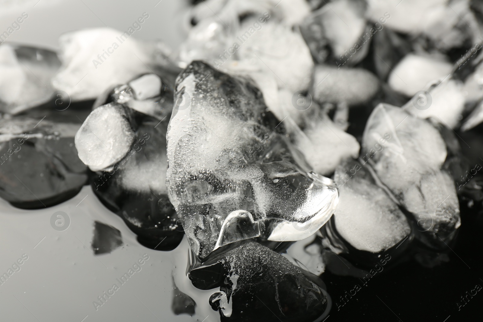 Photo of Pieces of crushed ice on mirror surface, closeup