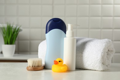 Photo of Baby cosmetic products, bath duck, brush and towel on white table