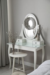 Photo of Elegant dressing table decorated with pussy willow branches indoors