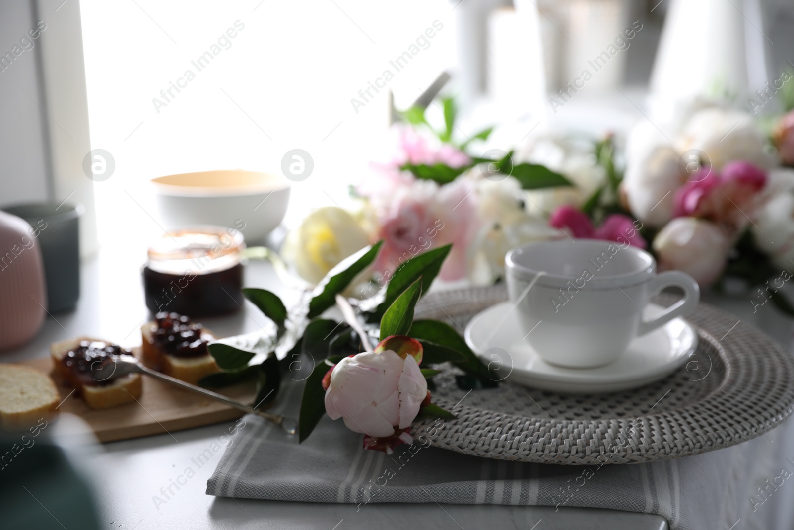 Photo of Beautiful peony and breakfast on table indoors