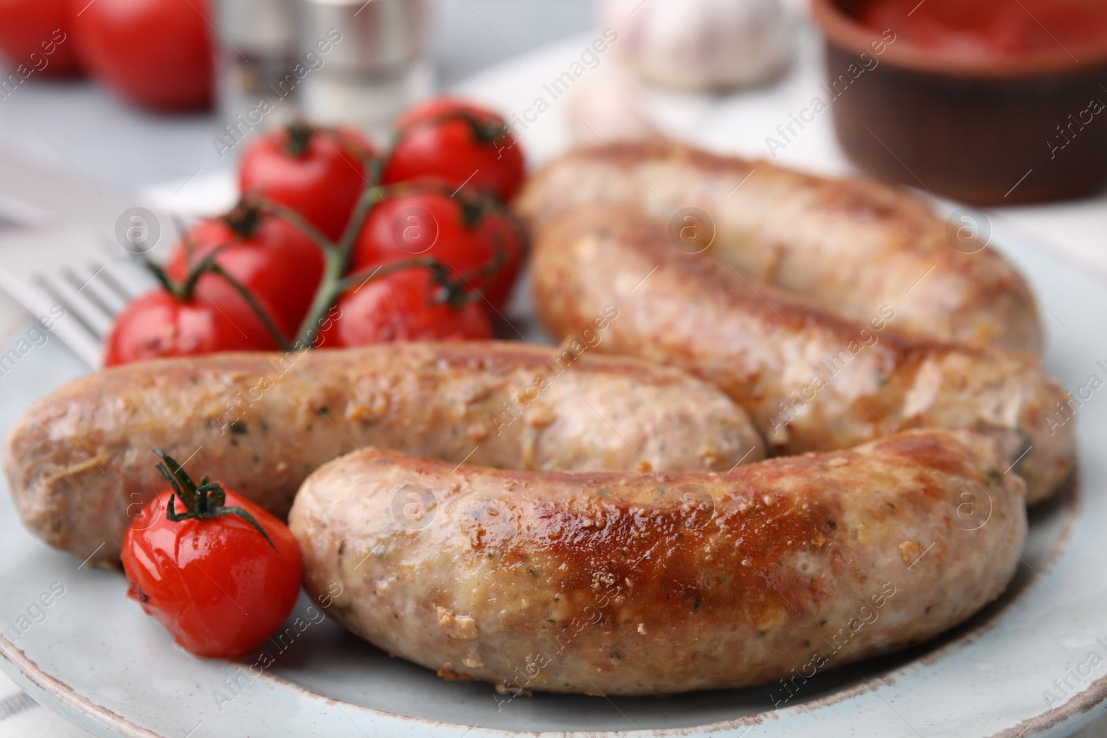 Photo of Plate with tasty homemade sausages and tomatoes, closeup