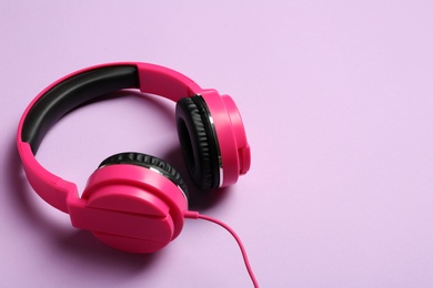 Photo of Stylish headphones on color background. Space for text