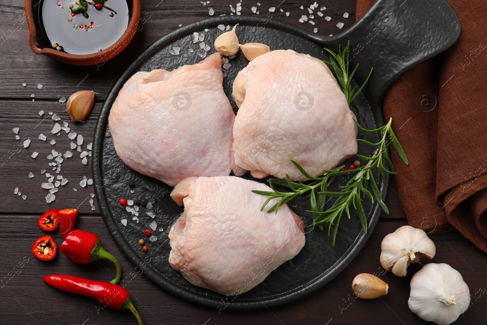 Photo of Raw chicken thighs and ingredients on wooden table, flat lay