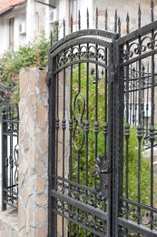 Photo of Entrance of yard with beautiful metal doors in fence outdoors