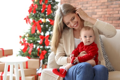 Young woman with baby celebrating Christmas at home