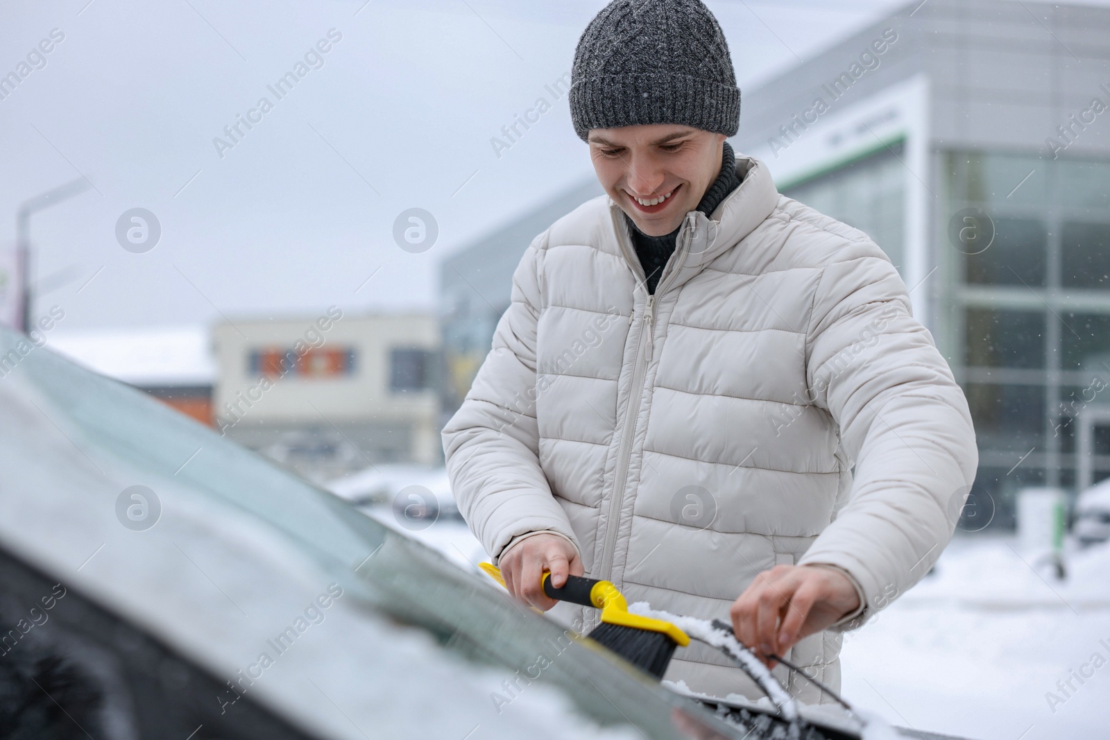 Photo of Man cleaning snow from car windshield outdoors, space for text