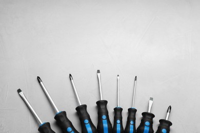 Photo of Set of screwdrivers on light grey background, flat lay. Space for text