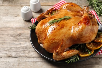 Photo of Tasty roasted chicken with rosemary and lemon on wooden table