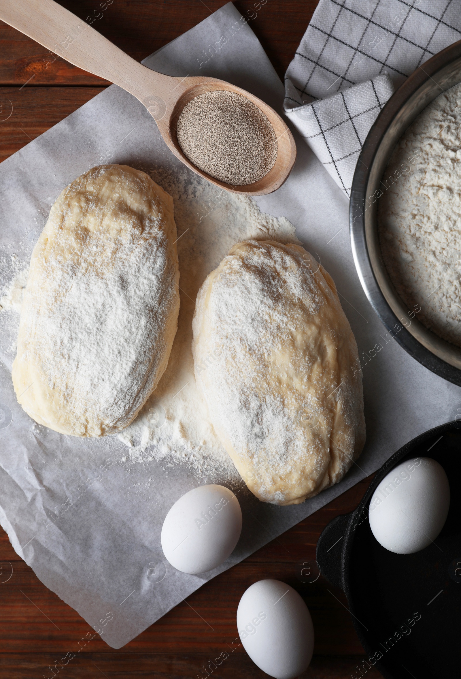 Photo of Raw dough, eggs and flour on wooden table, flat lay. Cooking ciabatta