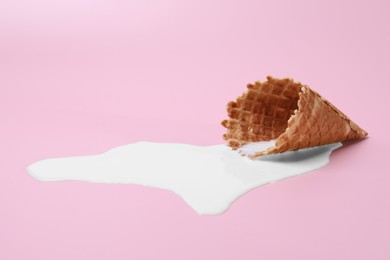 Photo of Melted ice cream and wafer cone on pink background