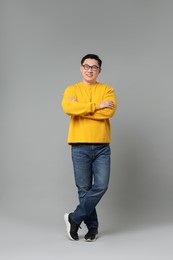 Full length portrait of happy man on grey background