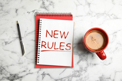 Flat lay composition with notebooks and text NEW RULES on marble background