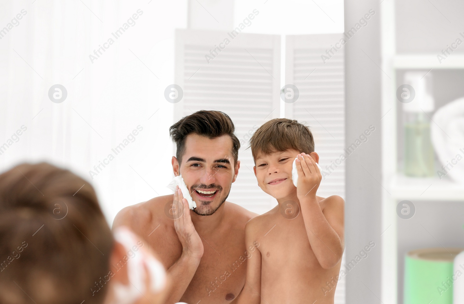 Photo of Father and son having fun while applying shaving foam in bathroom