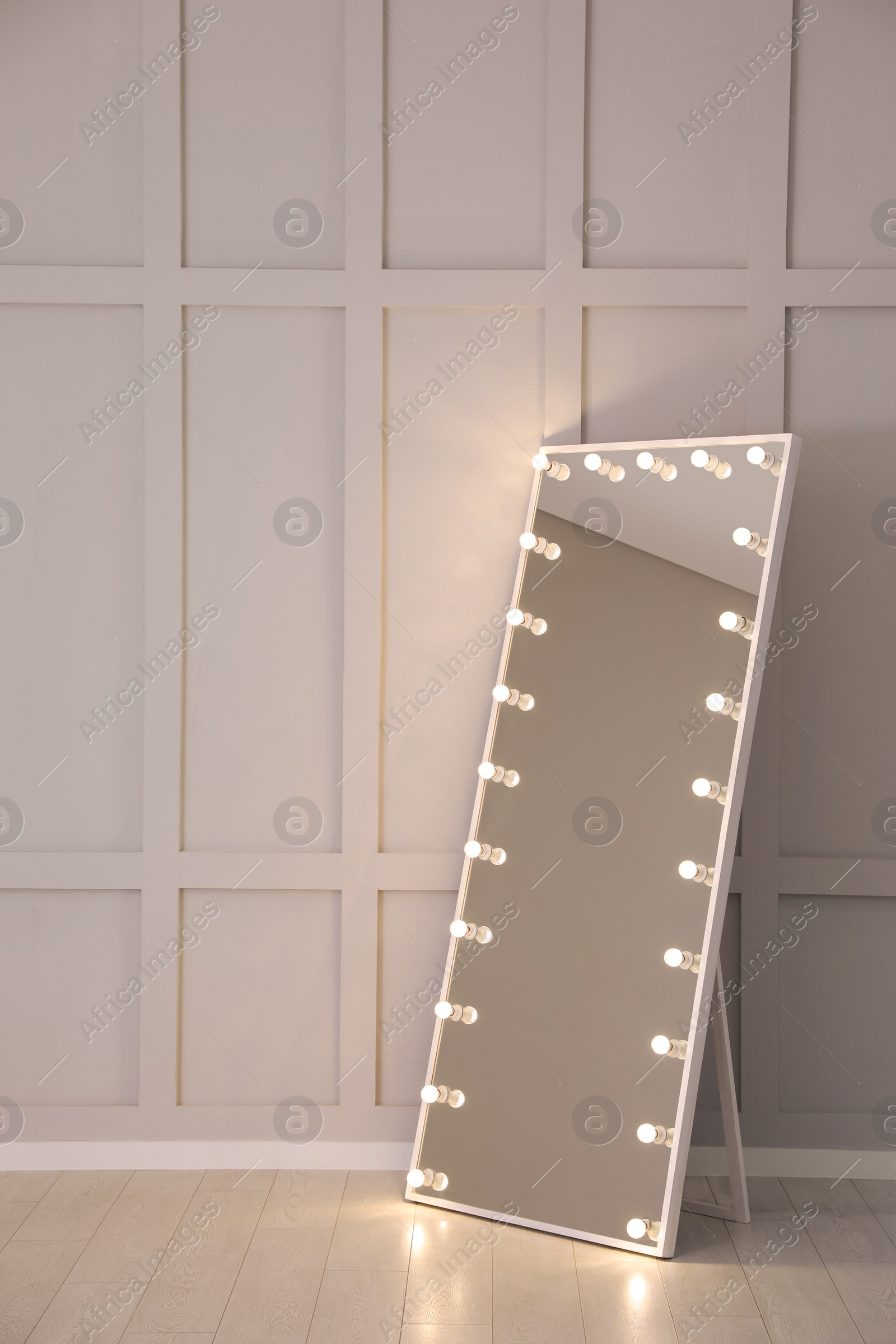 Photo of Modern mirror with light bulbs near molding wall in room, space for text