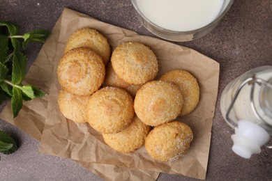 Photo of Tasty sweet sugar cookies, mint and milk on brown table, flat lay