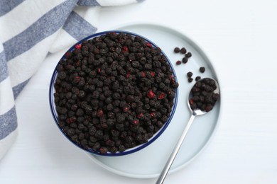 Photo of Bowl and spoon with dried blueberries on white wooden table, top view