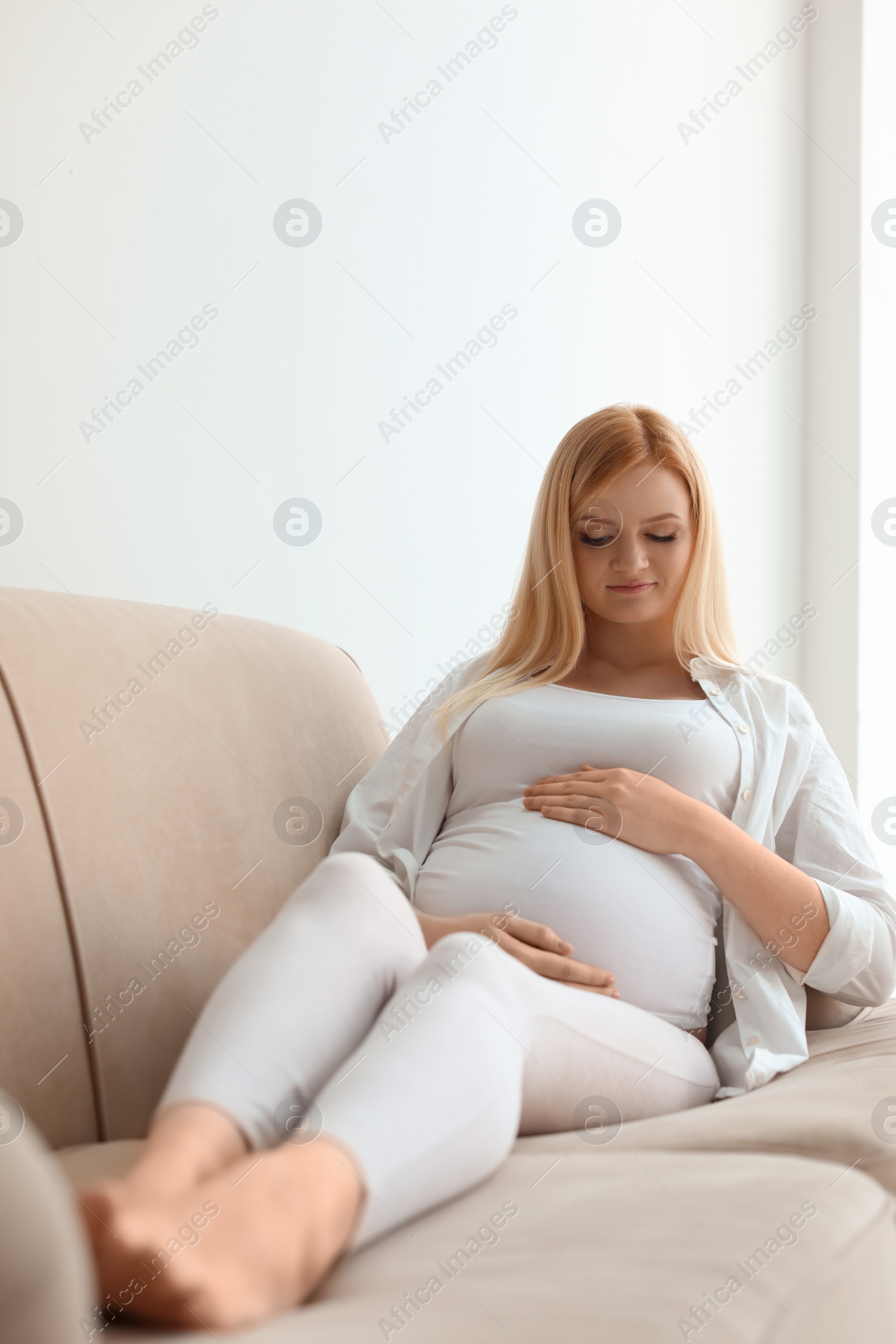 Photo of Beautiful pregnant woman resting on sofa at home