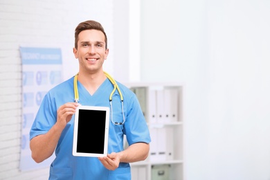 Photo of Portrait of medical assistant with stethoscope and tablet in hospital. Space for text