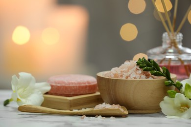 Beautiful composition with different spa products and flowers on white marble table against blurred background