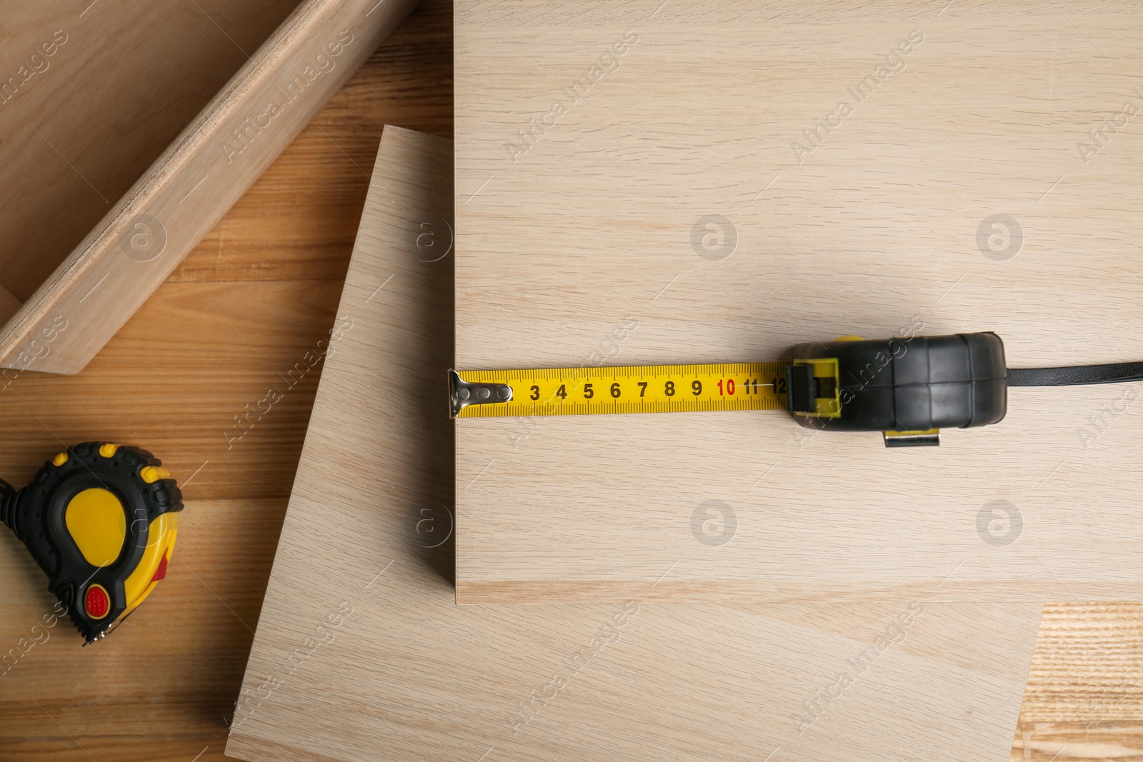 Photo of Tape measure on wooden surface, flat lay