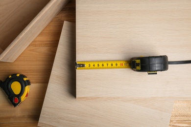 Tape measure on wooden surface, flat lay