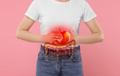 Woman suffering from stomach ache on pink background, closeup. Illustration of unhealthy gastrointestinal tract