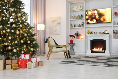 Photo of Beautiful tree with festive lights and Christmas decor in living room. Interior design