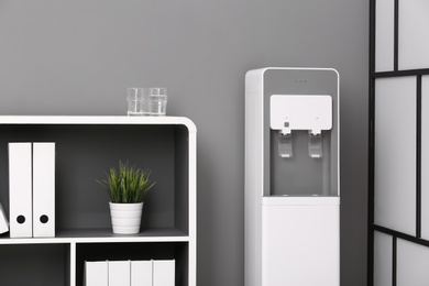 Photo of Modern water cooler in stylish office interior