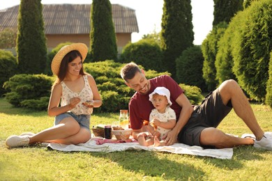 Photo of Happy family having picnic in garden on sunny day