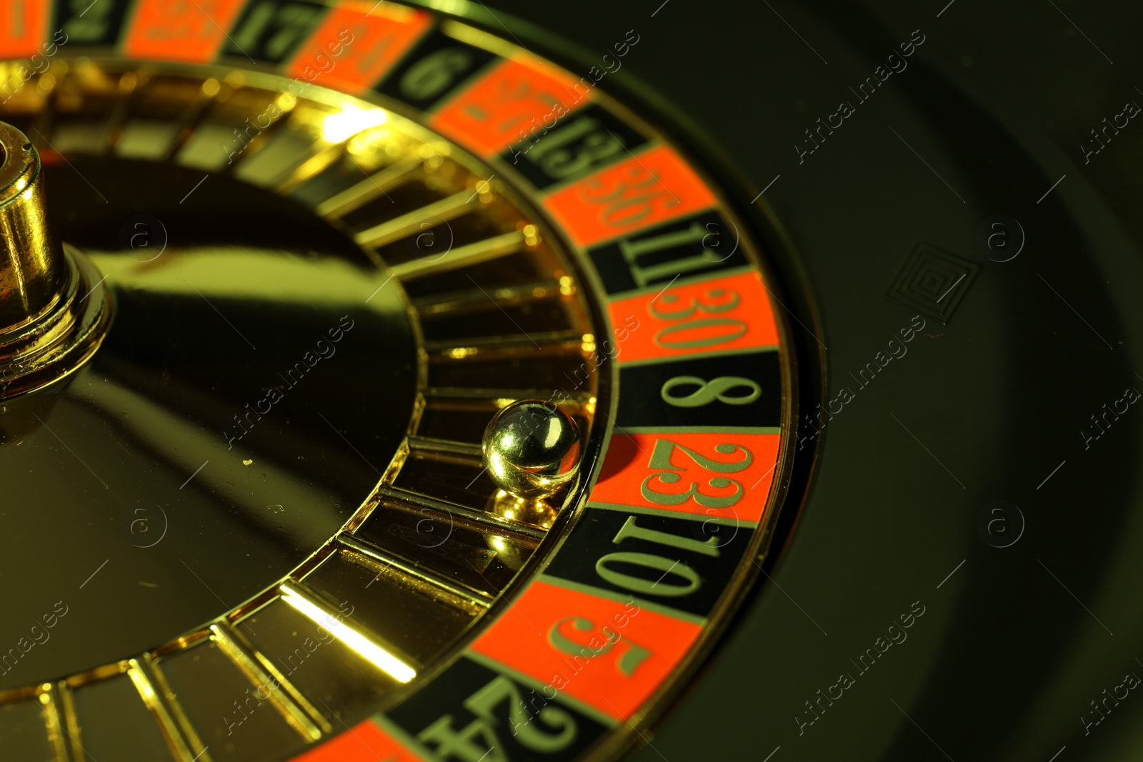 Photo of Roulette wheel with ball, closeup. Casino game