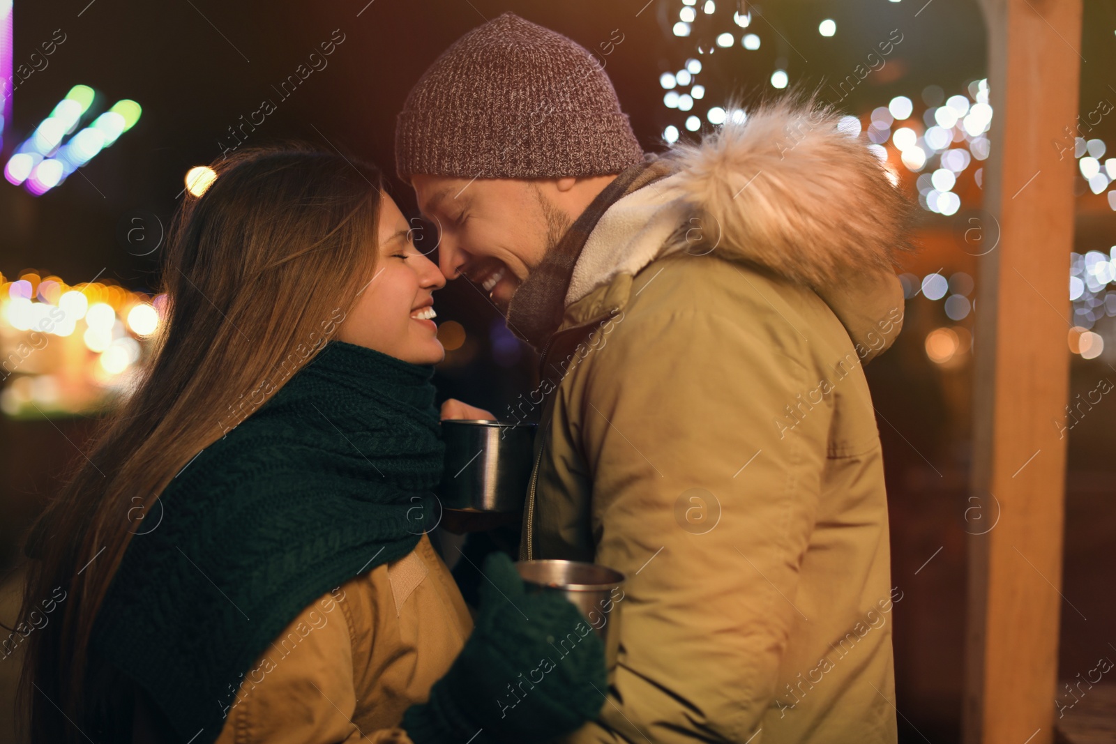 Photo of Happy couple with mulled wine at winter fair