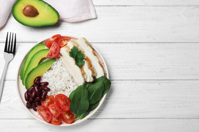 Photo of Delicious rice with beans and meat served on white wooden table, flat lay. Space for text