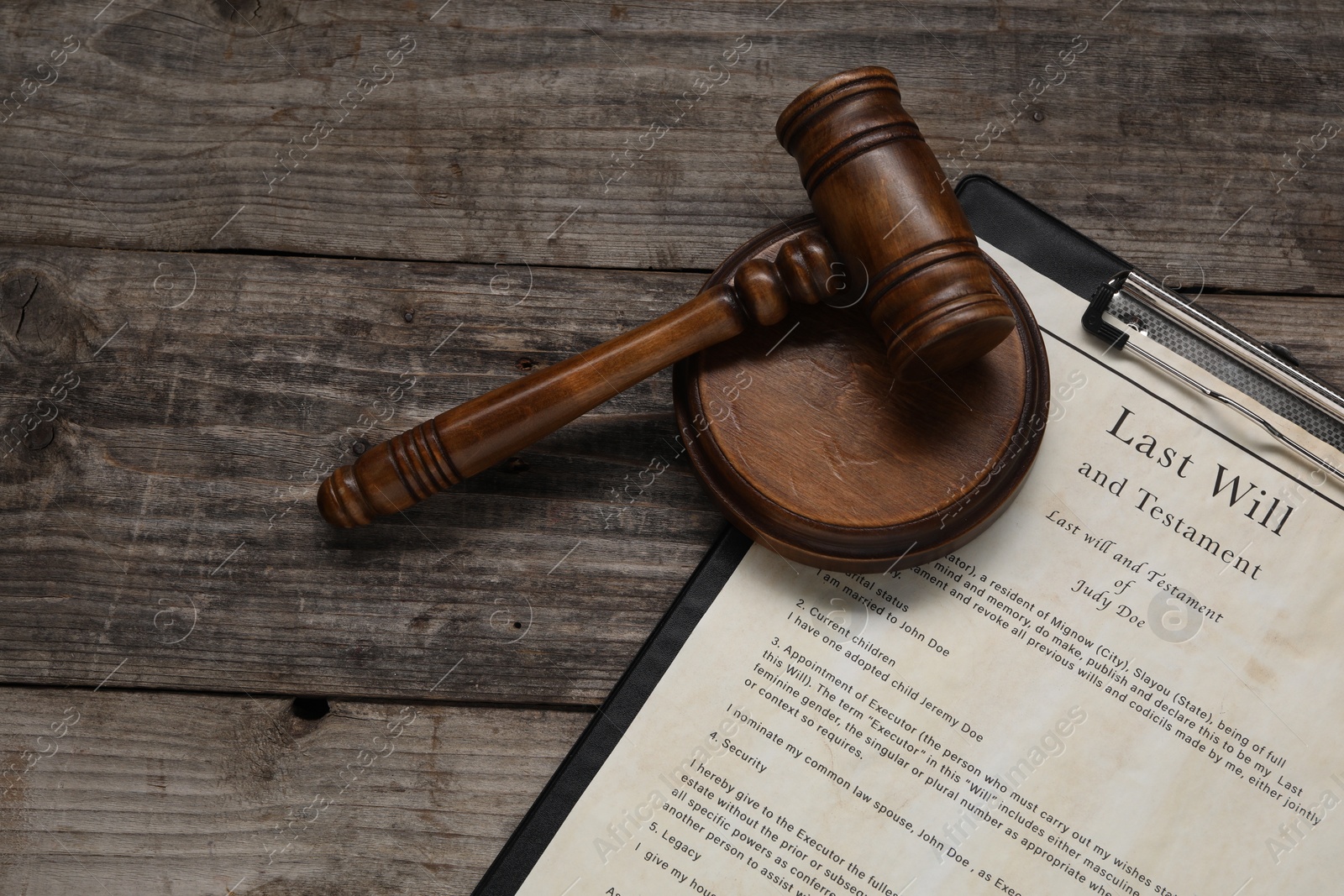 Photo of Last Will and Testament with gavel on wooden table, top view