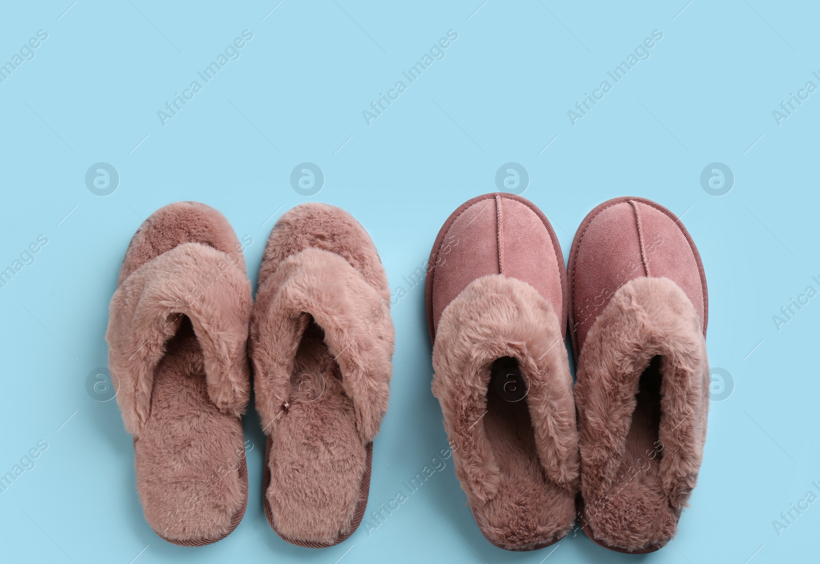 Photo of Different stylish soft slippers on light blue background, flat lay