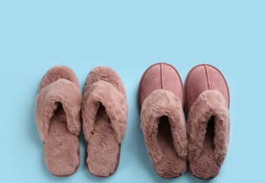 Different stylish soft slippers on light blue background, flat lay