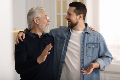 Photo of Happy son and his dad talking at home