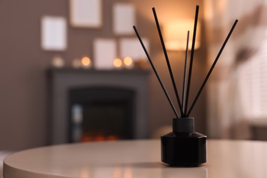 Photo of Reed diffuser on white table indoors. Space for text