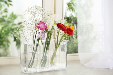 Photo of Beautiful fresh flowers on window sill indoors