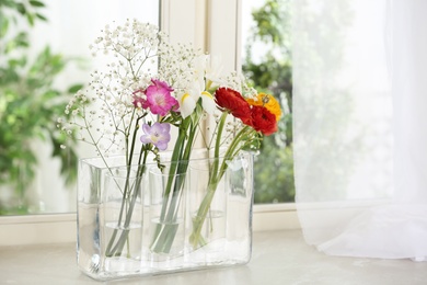 Beautiful fresh flowers on window sill indoors